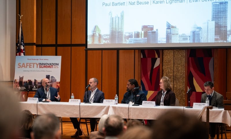 An auditorium of people listening to a table of panelists.